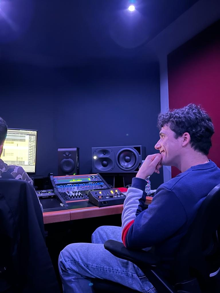 Jam Mattia in studio di registrazione professionale davanti a monitor e console: oltre che DJ è anche producer, con brani pubblicati su Spotify