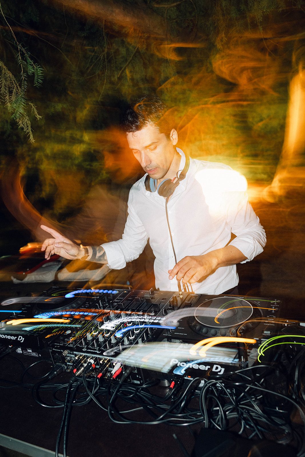 Jam Mattia mixa su console Pioneer durante la festa di matrimonio a Villa Ca' Sagredo, luci calde e movimento della pista sullo sfondo