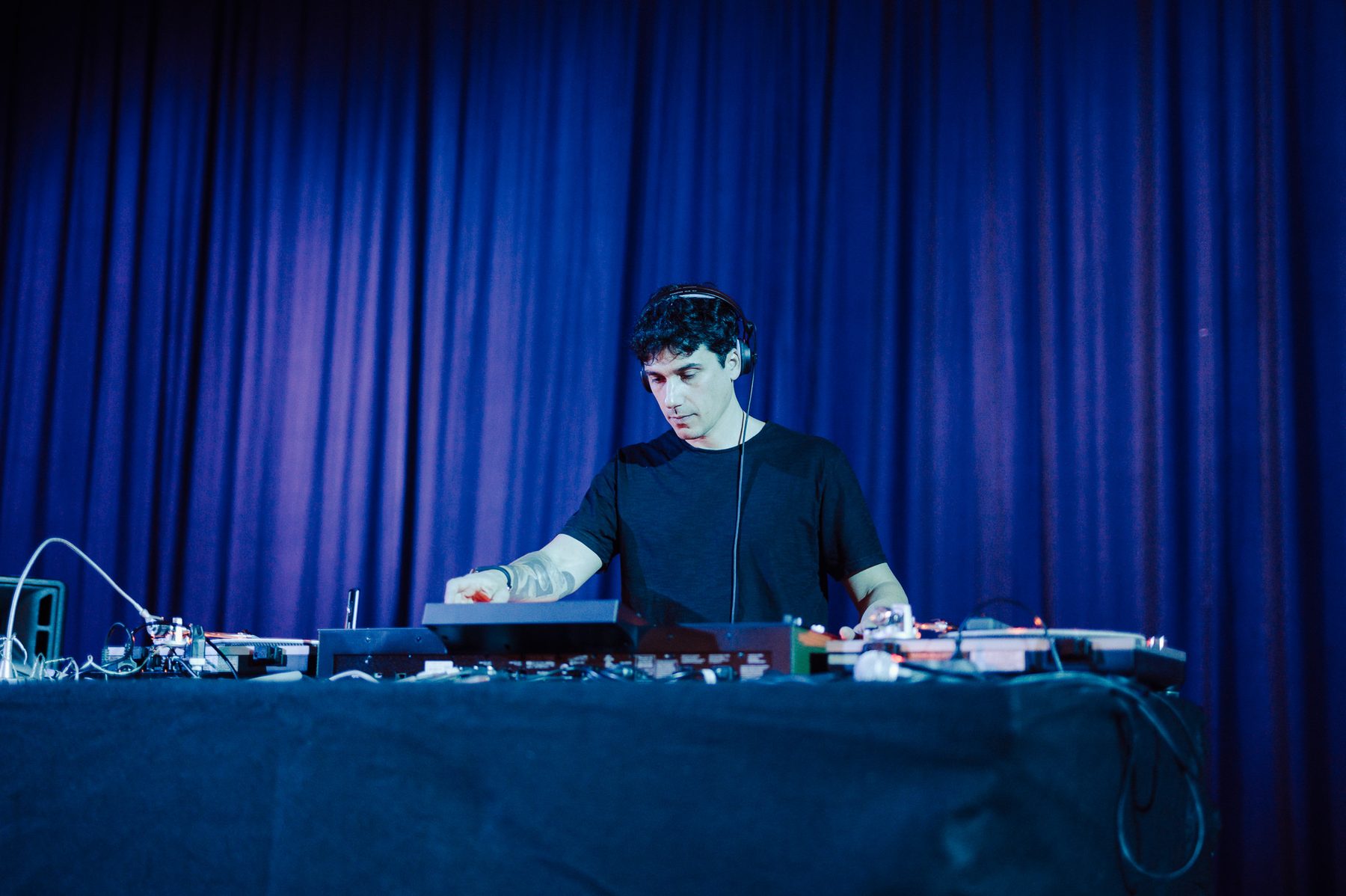 Jam Mattia in DJ set per una festa corporate, console e giradischi davanti a un tendaggio blu