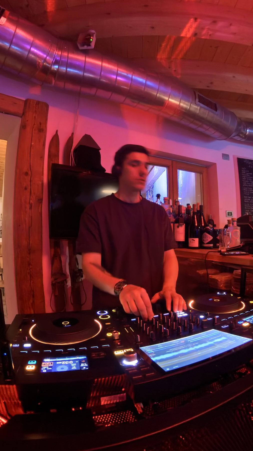 DJ set in una baita privata in montagna nel cuore delle Dolomiti: Jam Mattia alla console tra luci rosse e legno, festa privata in quota