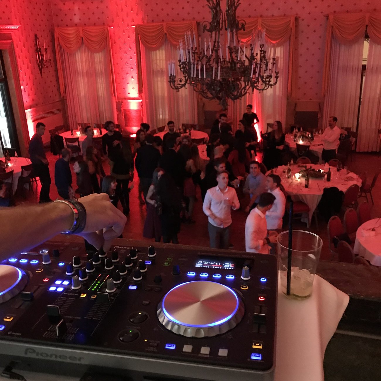 DJ set per festa privata al Caffè Pedrocchi di Padova: controller Pioneer in primo piano e sala storica con lampadario illuminata di rosso