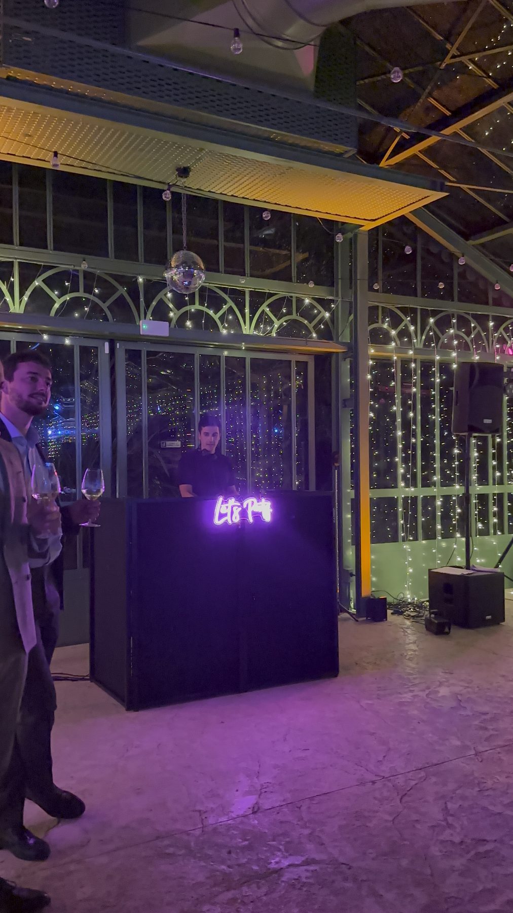 Setup DJ interno nella serra di Villa Solatia (Caldogno, Vicenza): postazione nera con insegna luminosa e tende di luci, pronta per la festa di matrimonio