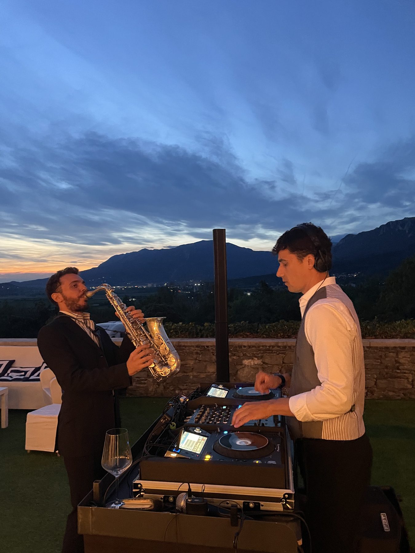 DJ set con sassofonista dal vivo al tramonto per un evento privato in Slovenia, montagne sullo sfondo e console Pioneer