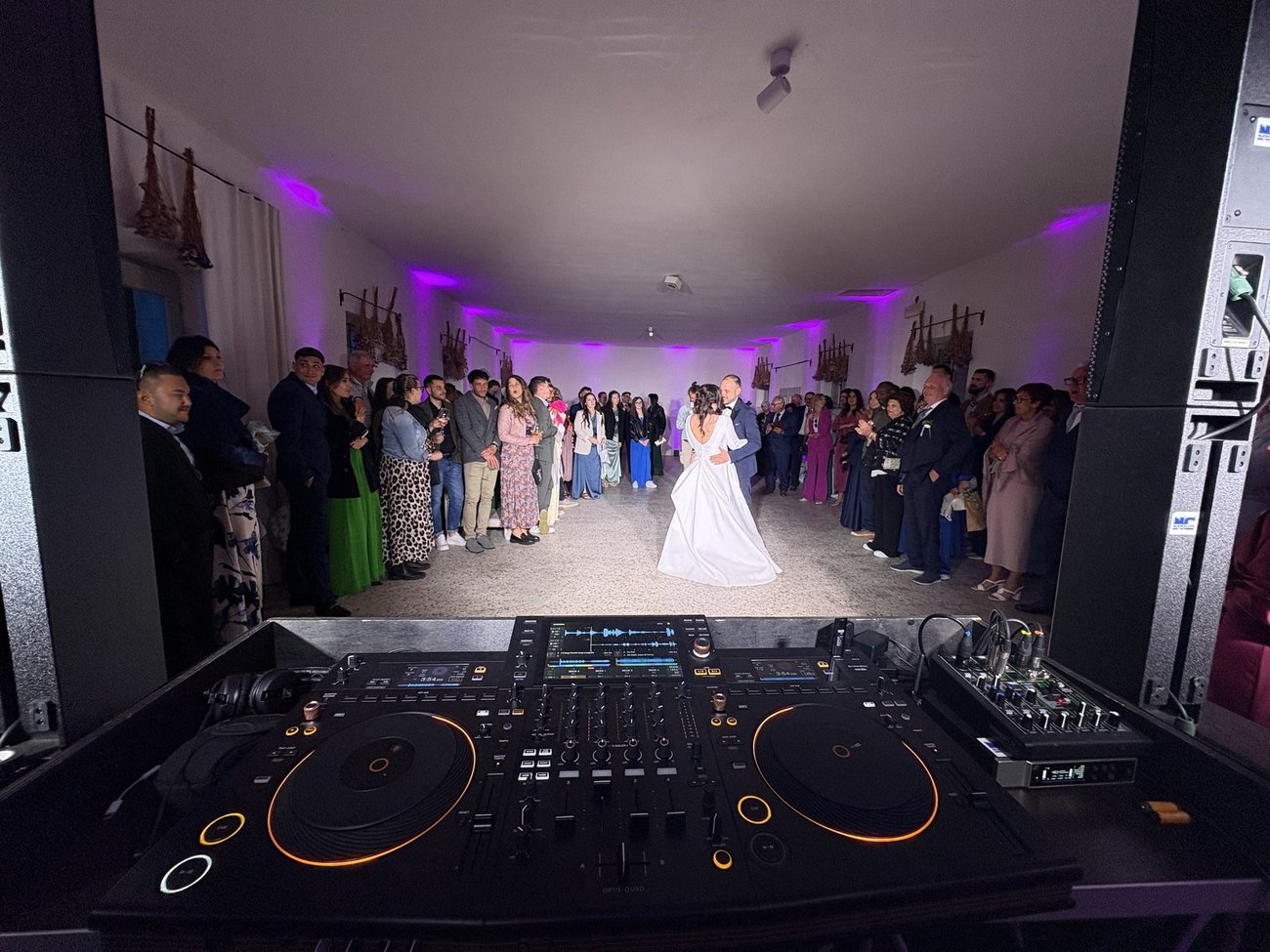 Allestimento interno a Borgo Garzolini (Buttrio, Udine) per un matrimonio in Friuli: setup DJ completo con illuminazione dinamica viola, la sposa e gli ospiti in sala