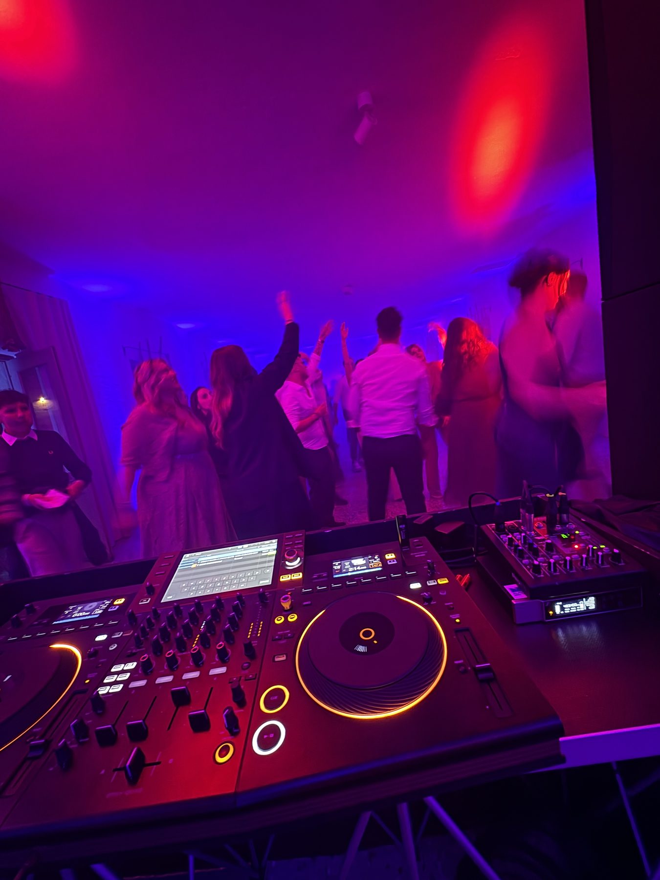 Festa di matrimonio a Borgo Garzolini (Buttrio, Udine): console Pioneer in primo piano e invitati che ballano sotto le luci rosa e blu