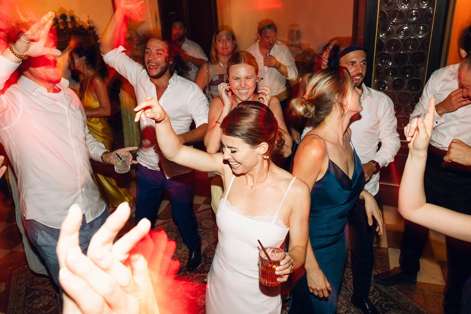 Wedding internazionale a Villa Sagredo (Vigonovo, Venezia): ospiti che ballano nel salone con allestimento di luci dedicate e dinamiche LED colorate