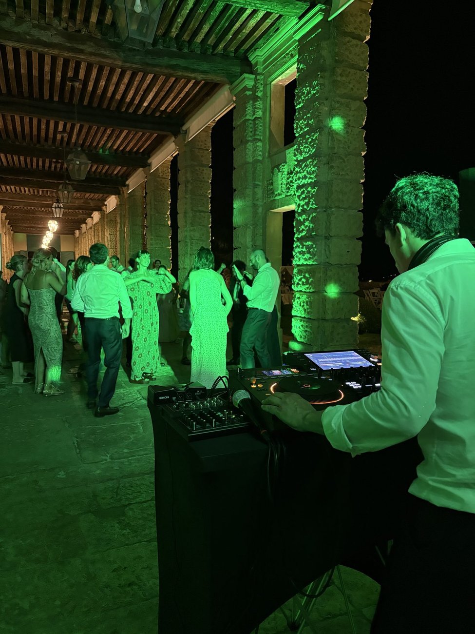 DJ set sotto il porticato di Villa di Montruglio (Mossano, Vicenza) con luci verdi: Jam Mattia alla console e ospiti all'aperitivo di matrimonio