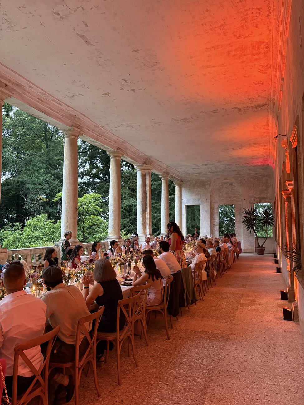 Cena di matrimonio sotto il porticato di Villa Mezzalira (Bressanvido, Vicenza) con luci ambra, tavolata lunga degli invitati sonorizzata da Jam Mattia