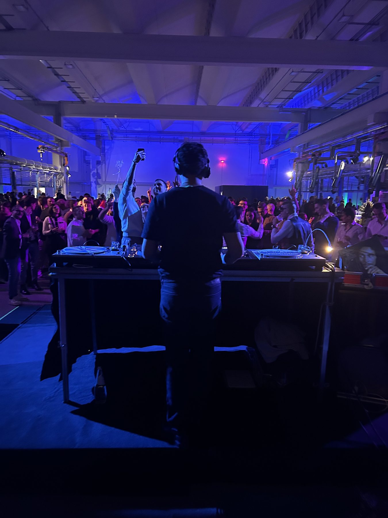 Evento corporate a Venezia: Jam Mattia di spalle alla console davanti a una platea di ospiti sotto le luci blu