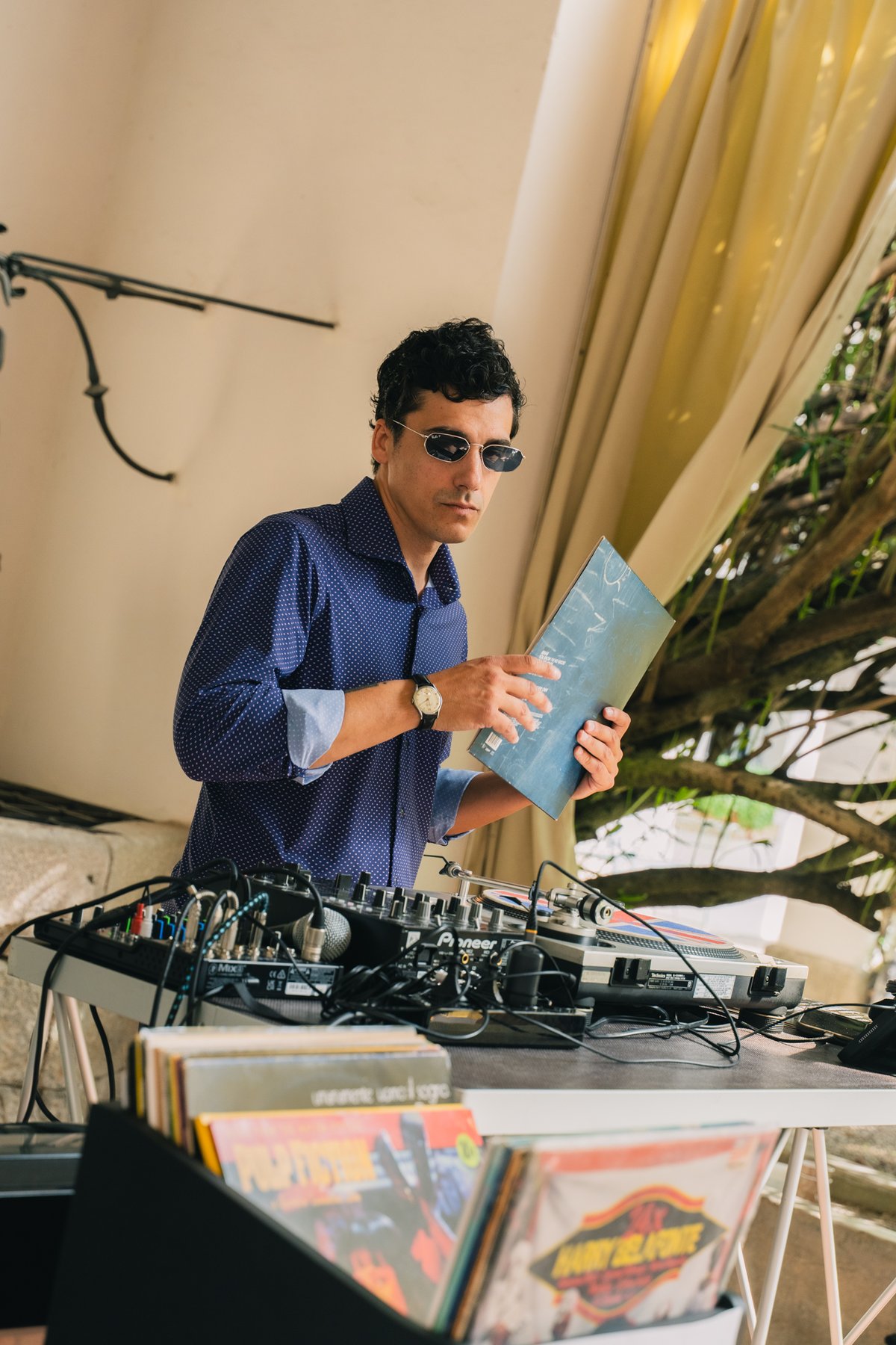 Vinyl Bar durante un aperitivo di matrimonio: Jam Mattia sceglie un disco dalle ceste di vinili davanti alla console, format in cui gli ospiti interagiscono con il DJ e i musicisti scegliendo i vinili da suonare